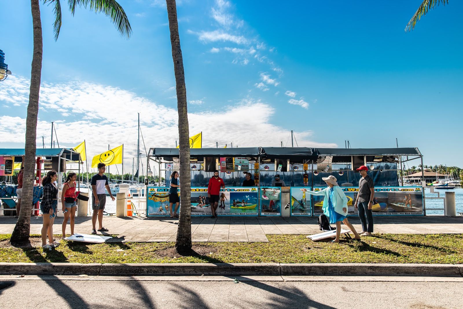 The check-in stand under the smiley flags, seen from the park walkway