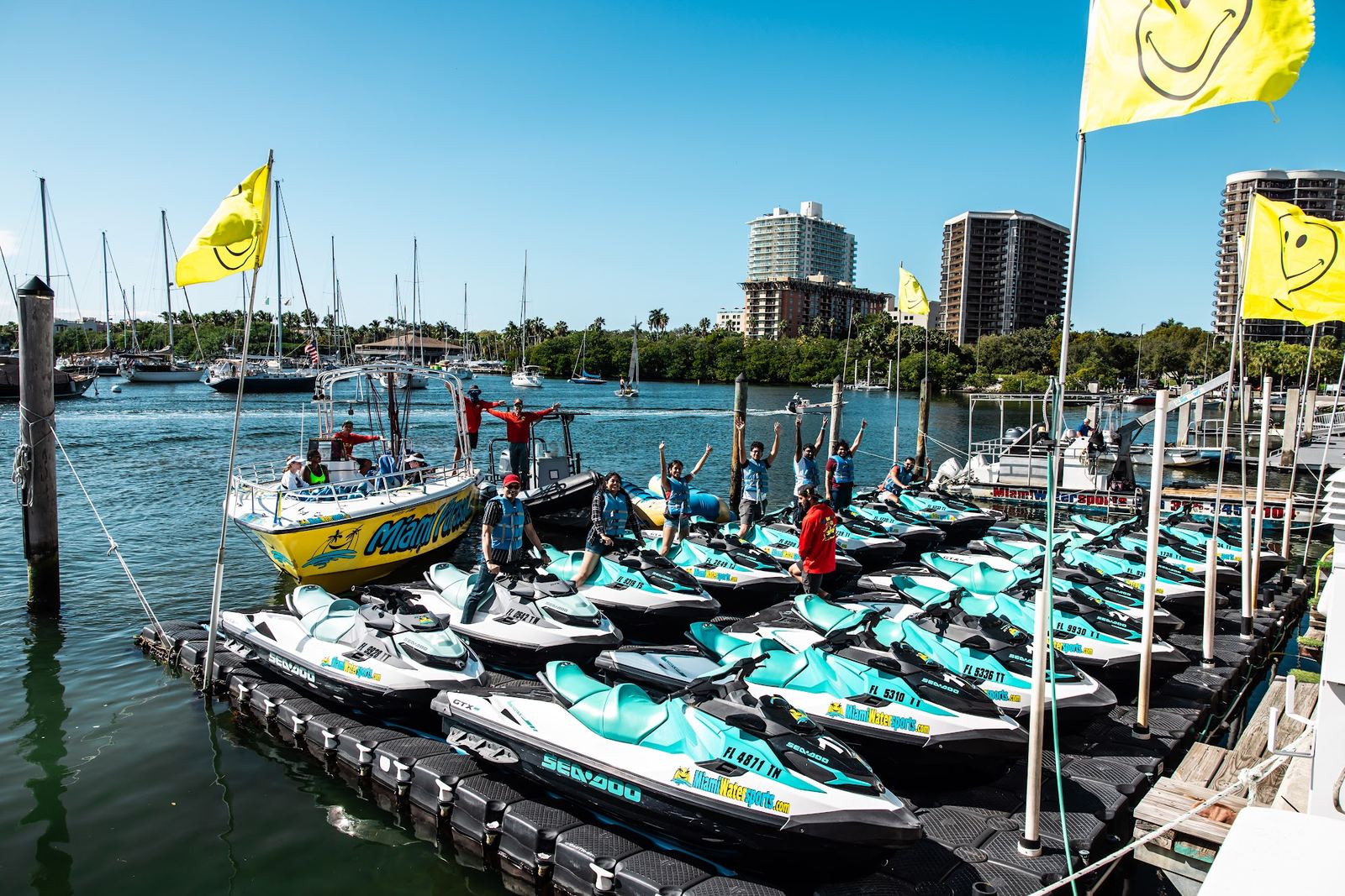 Rows of jet skis at the dock with the smiley flags and towers behind