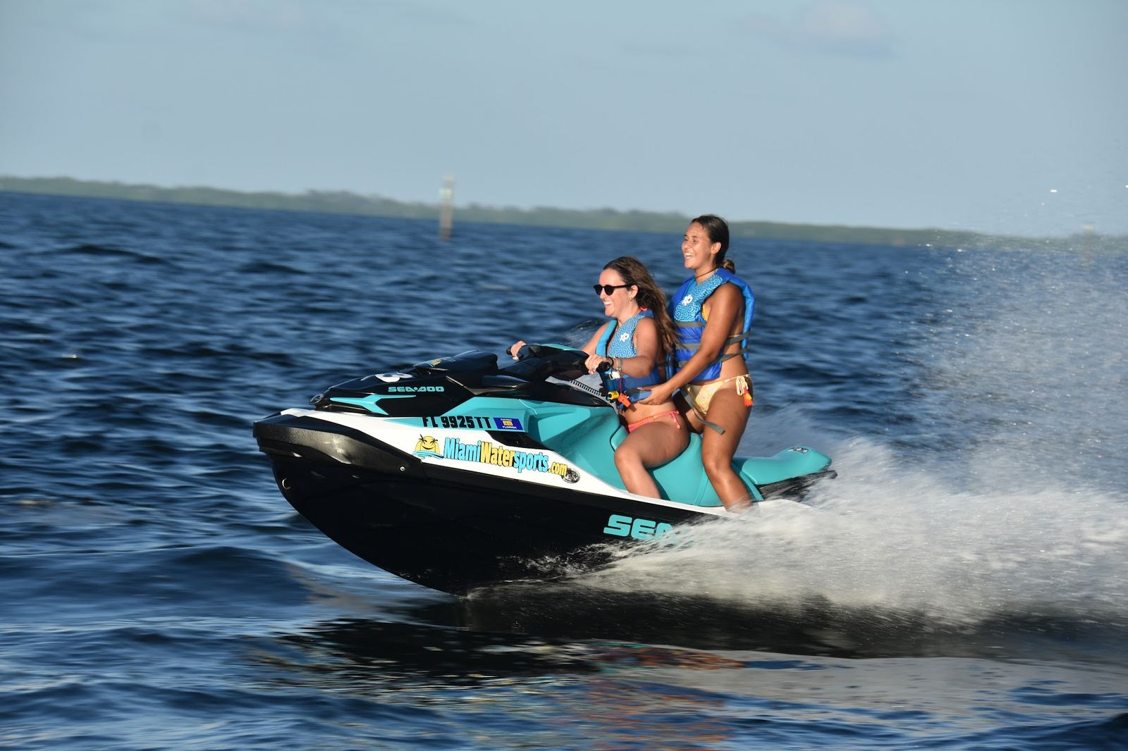 Couple cruising on a jet ski on calm bay water
