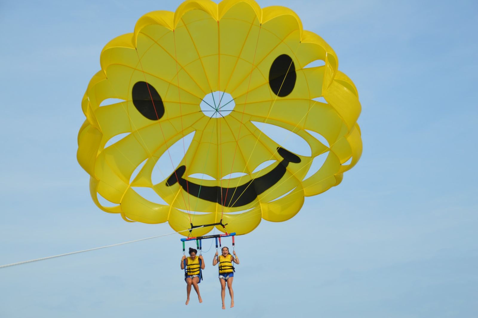 The smiley-face parasail canopy high over Biscayne Bay
